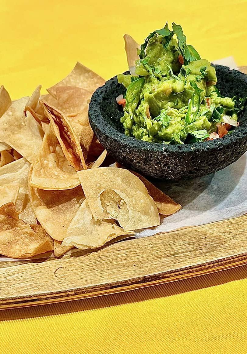 A plate of chips and guacamole.